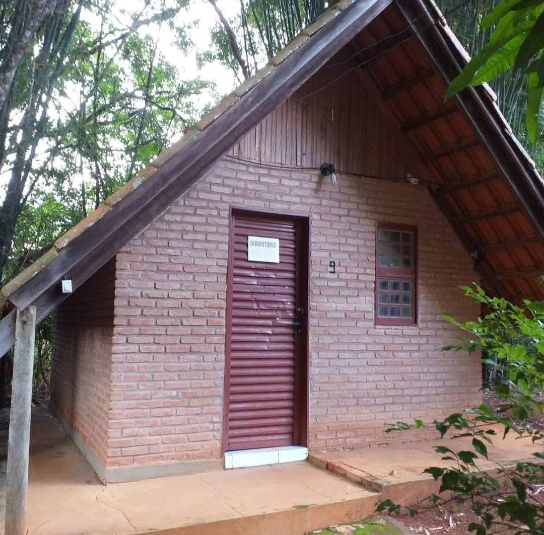 Chalé dormitório de tijolo entre as árvores